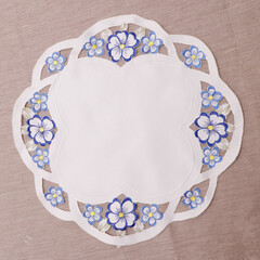 beautiful white fabric doily with blue flowers