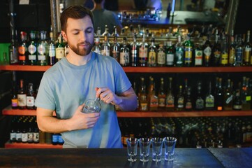 Handsome bar tender standing behind his counter in a pub