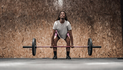 woman carrying a heavy barbell in the gymnasium