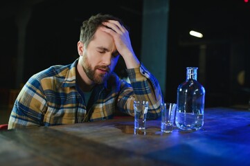 Sad man sitting at bar counter, alcohol addiction
