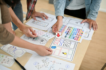 A close-up top view image of a group of developers is in the meeting