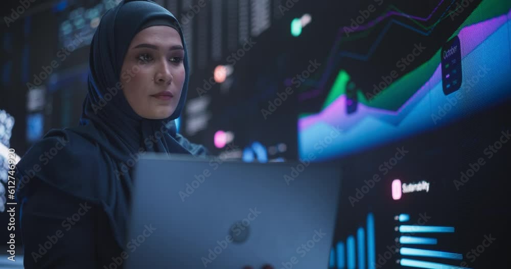 Poster Portrait of Arab Female Working in an Advanced Technology Company. Woman Wearing a Hijab, Using Laptop Computer in a Room with an Artificial Intelligence Neural Network Software on a Digital Screen