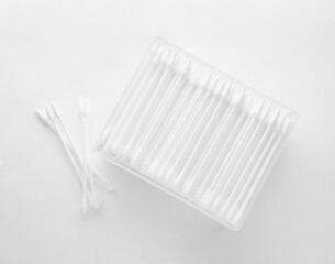 Cotton buds in plastic container isolated on white, top view