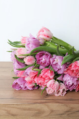 Beautiful bouquet of colorful tulip flowers on wooden table