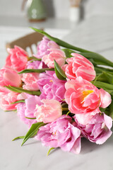Beautiful bouquet of colorful tulip flowers on white table indoors