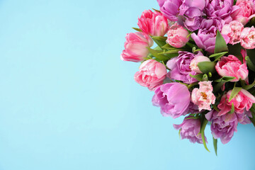 Beautiful bouquet of colorful tulip flowers on light blue background, top view. Space for text