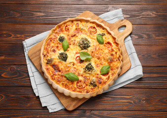 Delicious homemade vegetable quiche on wooden table, top view
