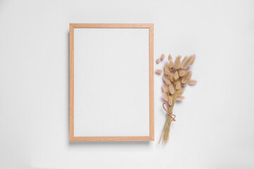 Empty photo frame and dry decorative spikes on white background, top view. Space for design