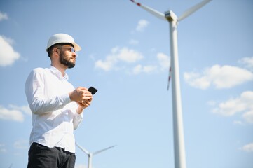 Engineer in field checking on turbine production