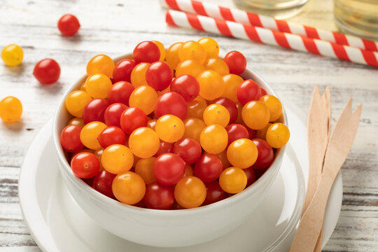 Bowl with fresh red and yellow Tomberry tomatoes close up 