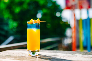 Fresh cold mango cocktail, mango juice smoothie in glass outdoors