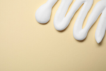 Sample of shaving foam on beige background, top view. Space for text