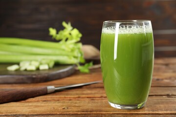 Glass of fresh celery juice on wooden table, closeup. Space for text