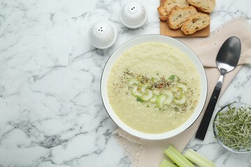 Delicious celery soup served on white marble table, flat lay. Space for text