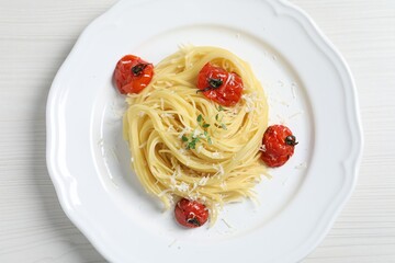 Tasty capellini with tomatoes and cheese on white wooden table, top view. Exquisite presentation of pasta dish