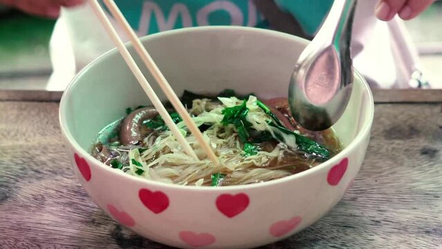 Rice Noodles Beef Soup with Beef Intestine Braised ontop Garlic and Stink Weed decorate Spring onions and Basil Thai herbs. Thai Boat Noodles Style topview