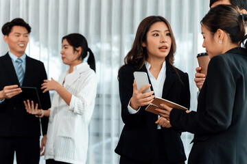 Mentor, manager with coffee advice younger colleagues in workplace. Businesspeople discussing or...