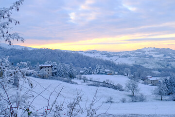 Blizzard in the mountains during sunset. Snowy hills, mountains,  village, nature, horizon. Natural background. Appennino-Tosco-emiliano