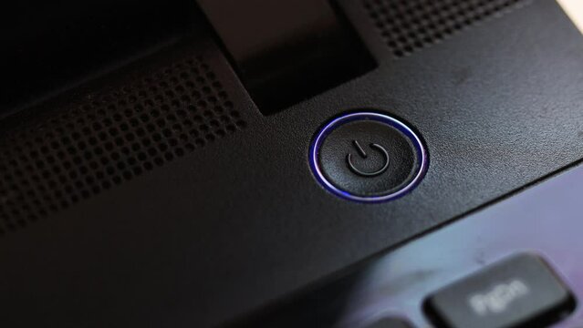 finger presses power button on laptop.