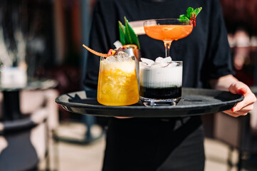 glasses alcohol cocktail set on a waiter tray in bar