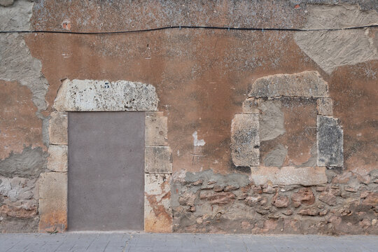 Vista de una casa de piedra abandonada y tapiada en un pueblo espa&ntilde;ol.