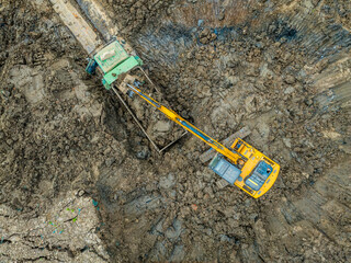 Aerial view of excavator equipment at the construction site. The excavator digs earthwork at the construction site.