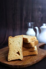 Tea Time Snack. Healthy Wheat rusk served with Indian hot masala tea and milk jug over black background. also known as Mumbai cutting chai. with Copy space. Crunchy rusk or toast.