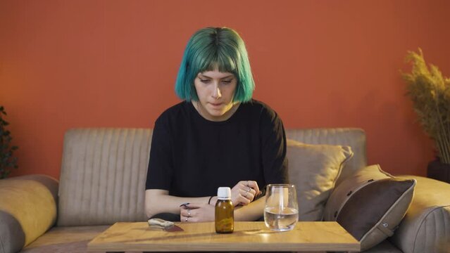 The young woman who looks at the pills in her hand and is going to commit suicide.