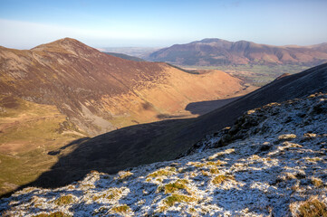 Views of Grisedale Pike above Coledale Beck with Skiddaw in the distance in winter in the English Lake District, UK.