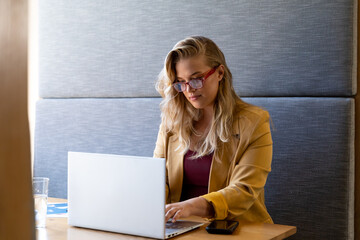 Happy plus size caucasian casual businesswoman in glasses using laptop at desk © WavebreakMediaMicro