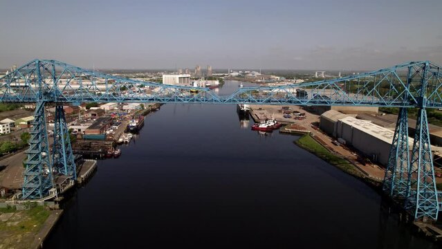 Drone flies backwards and fast from Transporter Bridge in Middlesbrough on a sunny spring morning.  
