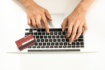 Close-up image capturing the hands of a young man as he shops online on a website, confidently and securely using a credit card to complete his payment.