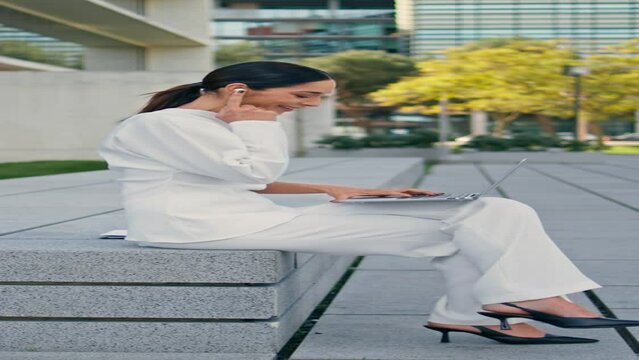 Businesswoman working laptop bench urban street vertically. Woman answering call