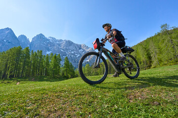 Naklejka na ściany i meble active senior woman on a mountain bike tour in the Julian Alps above Kranska Gora in Slovenia