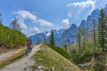 Fototapeta na wymiar active senior woman on a mountain bike tour in the Julian Alps above Kranska Gora in Slovenia