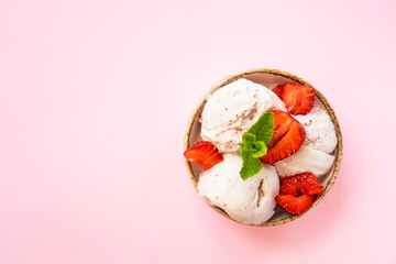 Homemade ice cream with fresh strawberries on pink background. Flat lay with copy space.