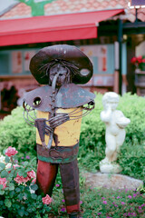 View of abstract garden statue playing saxophone made from iron in garden with defocused...