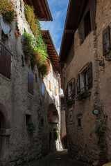 Fototapeta na wymiar Via Ettore Fieramosca in the medieval village of Canale di Tenno, Trentino-Alto Adige, Italy. Tenno is included in the list of the most beautiful villages in Italy