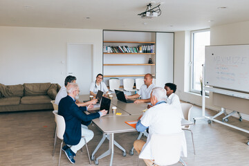 doctors in conference room sitting in business meeting