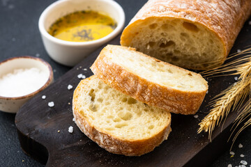 Italian Ciabatta bread on wooden board with olive oil. Close up.