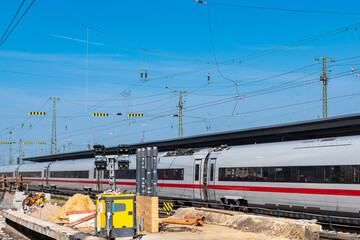 Construction and repair work on the railway line. Passenger train in the background.