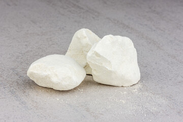 white pieces of quicklime close-up on a gray background