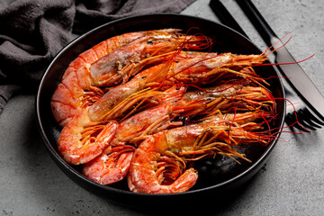 Giant argentinian red prawns, grilled. Black plate with cooked seafood. Dark grey background. - obrazy, fototapety, plakaty