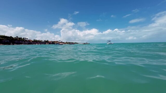 Handheld action camera shot from inside the ocean with tropical turquoise water at the Tambaba beach in Conde, Paraiba, Brazil on a warm sunny summer day.