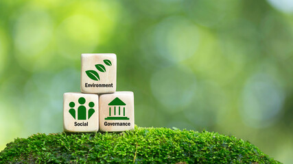 The word ESG on the wooden block. Future environmental protection and sustainable development. using the technology of renewable resources ESG related icons on wooden blocks and green background.