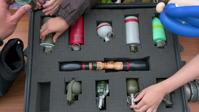 Visitors, including school children, engage with dummy explosive weapon ammunition during a police training exercise.
