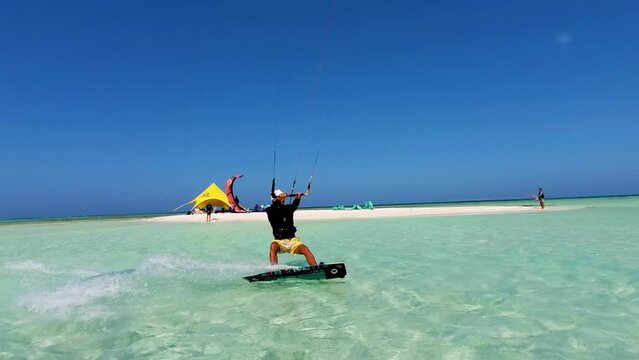 Man sail on caribbean sea water and jump doing kitesurfing tricks, los Roques