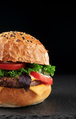 Delicious cheeseburger on black background, closeup. Space for text