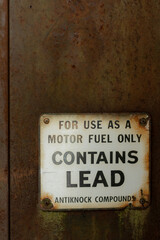 Signage on an antique, rusty gas pump. Contains lead.