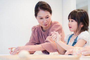孫と一緒にお菓子作りをするおばあちゃん